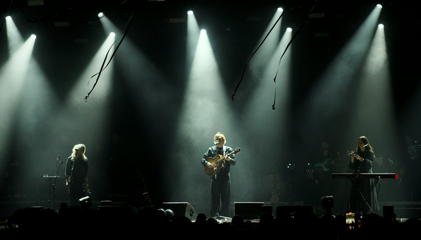 Tre musicisti si esibiscono insieme su un palco da concerto dal vivo.